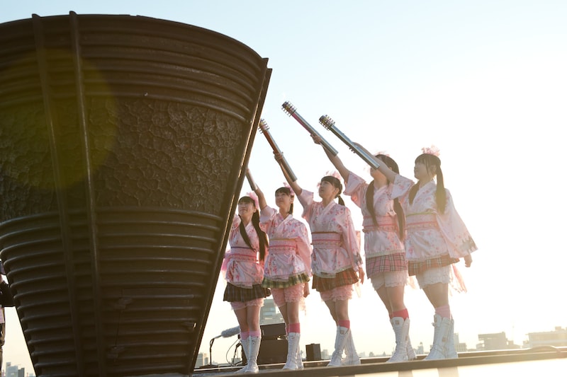 国立競技場の聖火台に点火するももいろクローバーZ。