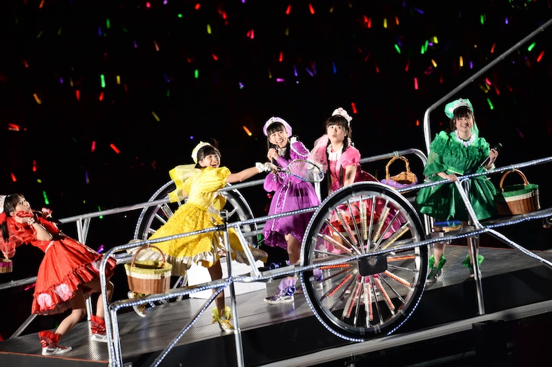 観客に向けてカラーボールをラケットで打つももいろクローバーZ。