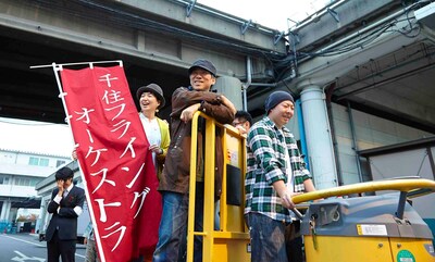 ターレーに乗って会場を視察する大友良英と参加者。