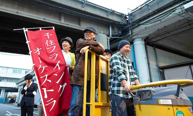 ターレーに乗って会場を視察する大友良英と参加者。