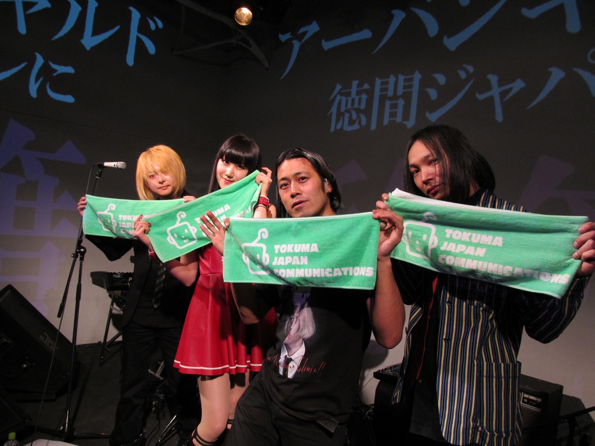 「アーバンギャルドの重大発表！＆松永天馬染髪式」で徳間ジャパンコミュニケーションズのロゴ入りタオルを掲げるアーバンギャルドのメンバー。