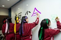 「天使とジャンプ！ももクロ大反省会！」のタイトルを描く様子。