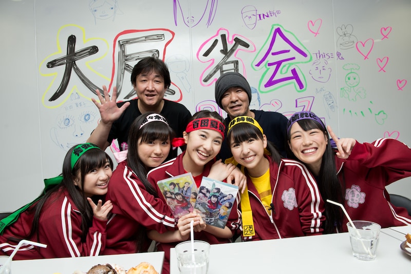 ももいろクローバーZと記念撮影をするプロデューサーの三鬼一希と演出の新田真三（後列左から）。