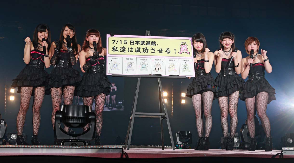日本武道館公演成功の誓約書ボードと記念撮影をするスマイレージ。