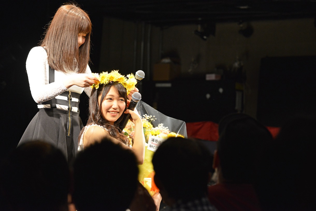 ファンから贈られた花かんむりをかぶる浦谷はるな（右）と、それを手伝う青木千春（左）。