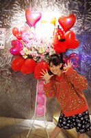 ファンから贈られた花を前に記念撮影する秋本帆華。