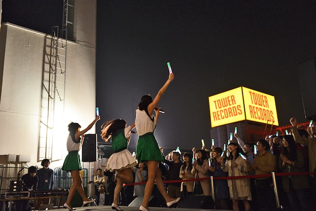 マルイシティ渋谷店の屋上で歌うNegicco。正面にはタワーレコード渋谷店の看板が見える。