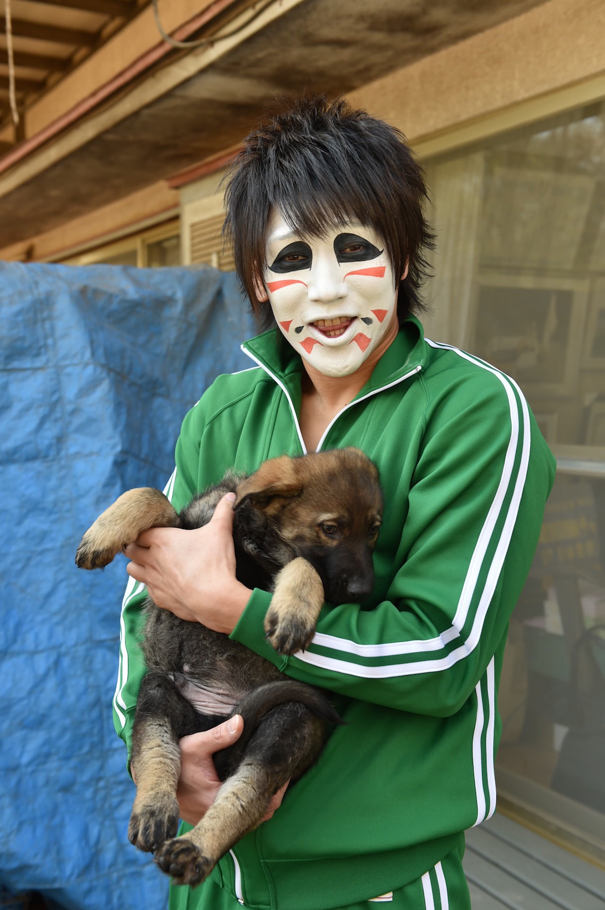 子犬を抱く樽美酒研二（Doramu）。