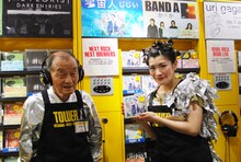 宇宙人「じじい」を試聴する菅登未男と、シングルを手に持つしのさきあさこ。