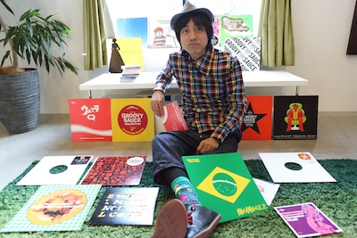 過去にリリースされた自身のアナログレコードに囲まれた中塚武。