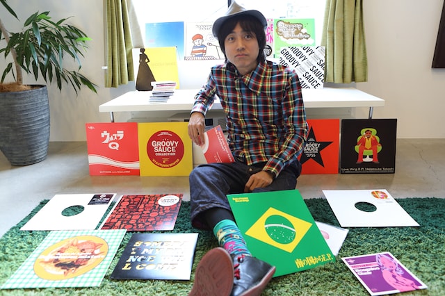 過去にリリースされた自身のアナログレコードに囲まれた中塚武。