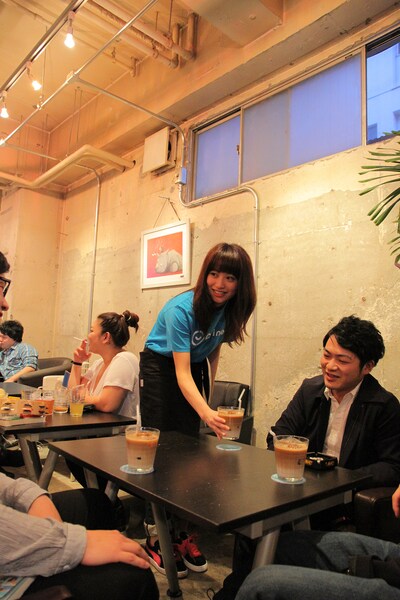 カフェ店員として接客するさいとうまりな。