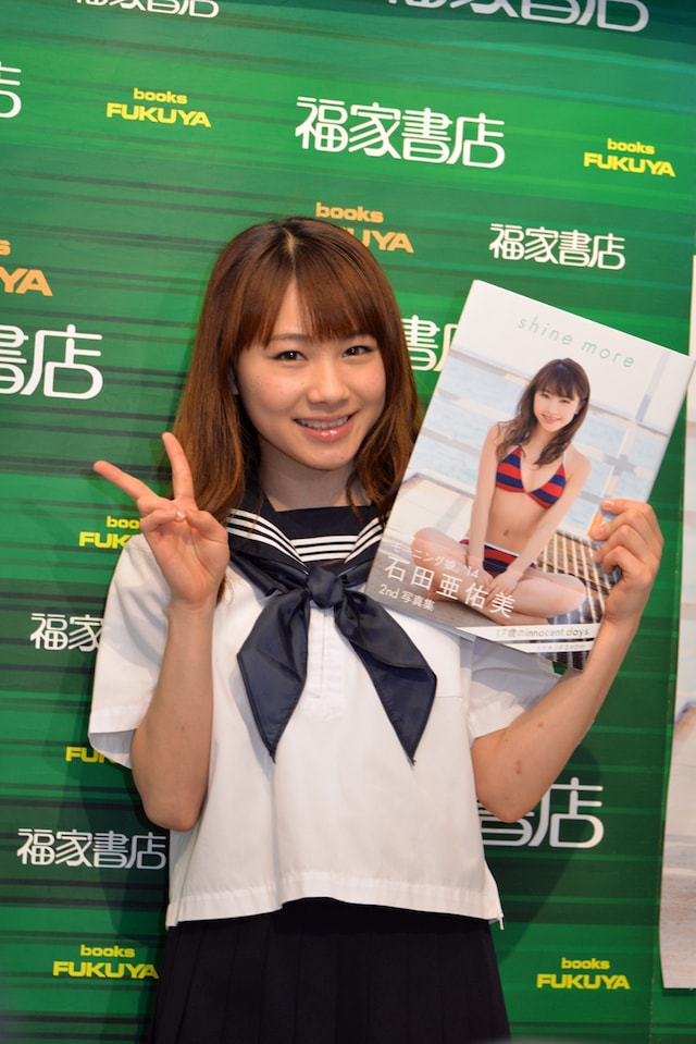 自身の写真集「shine more」を手にした石田亜佑美。