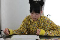 真剣な表情でメッセージを書く伊藤千由李。