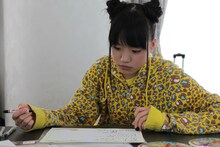 真剣な表情でメッセージを書く伊藤千由李。