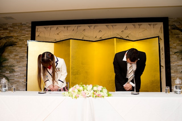 9thアルバムのタイトルが現段階で発表できないことを謝罪し、深々と頭を下げるほっちゃん（左）と謎の中年男性（右）。