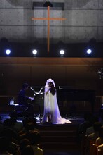 十字架を背に「hologram」を歌う牧野由依。