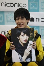 タカシのパネルを持つユースケ。