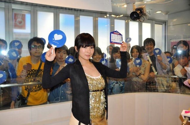 「サッカー日本代表応援絵馬」を手に撮影に応じる椎名林檎。