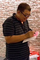 スタッフのために著書にサインをする川上アキラ。