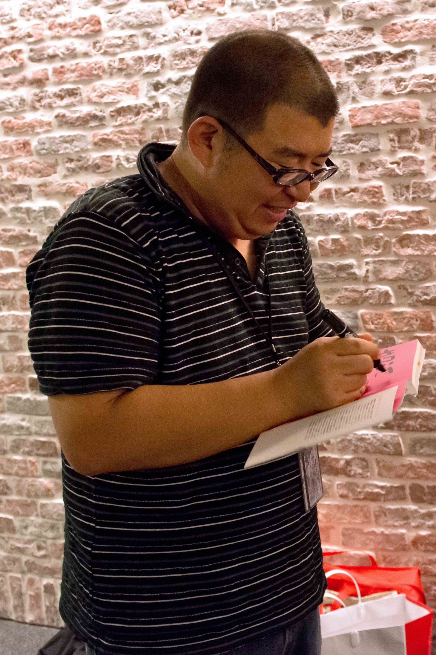 スタッフのために著書にサインをする川上アキラ。