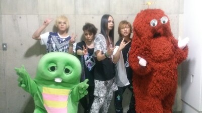 ガチャピンとムックと記念撮影をするバンドのムック。