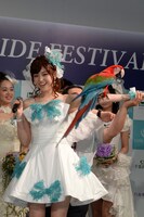 ベニコンゴウインコ「モリー」を腕に乗せる松村沙友理。