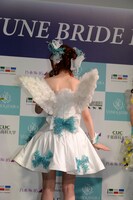 ウエディングドレスの背中に生えた羽根を見せる松村沙友理。