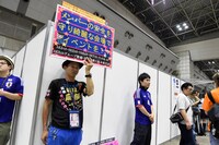 プラカードで会場の美化を呼びかけるファン。 (c)AKS