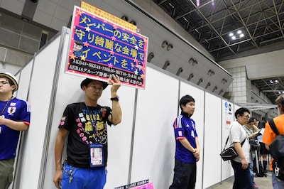 プラカードで会場の美化を呼びかけるファン。 (c)AKS