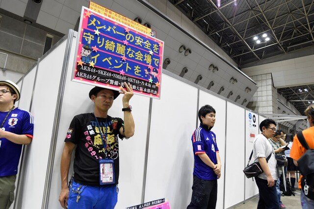 プラカードで会場の美化を呼びかけるファン。 (c)AKS