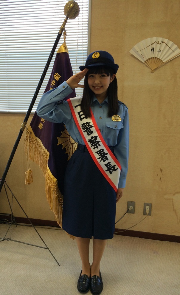 女性警察官の制服姿で敬礼する武田舞彩（GEM）。
