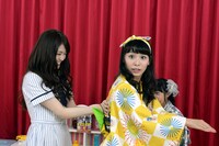 宮崎理奈（右）の背中を「お触り占い」する松村沙友理（左）。