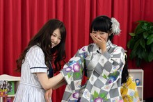 渡邉幸愛（右）の腕を「お触り占い」する松村沙友理（左）。