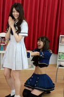 松村沙友理（左）のお尻を「お触り占い」するユカフィン・ドール（右）。