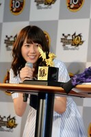 「モンスターハンター」のキャラクター、アイルーの純金製グッズ（手前）を眺める永島聖羅（奥）。グッズの価格は1体299万円（税別）。