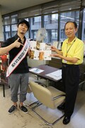 「広島汁なし担担麺PR大使」のタスキをかけ、広島県庁を訪れた増子直純（左）。