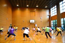 入念なストレッチでスポーツ大会本番に備える小池と参加者たち。