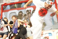 尻相撲で勝負するアイドリング!!!メンバー（奥）と越中詩郎（手前）。