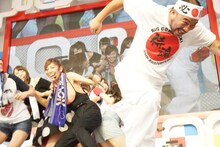 尻相撲で勝負するアイドリング!!!メンバー（奥）と越中詩郎（手前）。