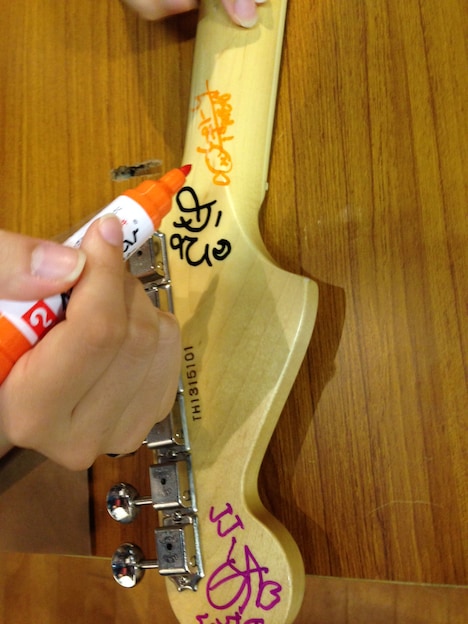 サインが書かれたファンの私物ギター。