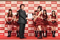 フェザー代表取締役社長の藤田直人より記念の楯を贈呈される山本彩。