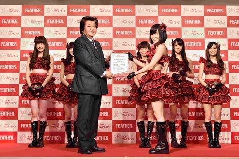 フェザー代表取締役社長の藤田直人より記念の楯を贈呈される山本彩。