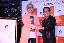 ガッチリ握手しながら「まるでドラフト契約みたいだね」と笑う箭内道彦（左）とさだまさし（右）。