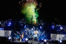 ライブの終盤で、花火をバックに熱演を繰り広げるONE OK ROCK。