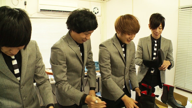 オーダーメイドのコラボブーツを手にするTHE BAWDIES。