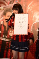 エル・シャーラウィ選手の似顔絵を見せる深川麻衣。