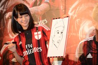 本田選手の似顔絵を見せる深川麻衣。