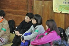 「森と風のがっこう」の校長の話に耳を傾けるつじあやの。