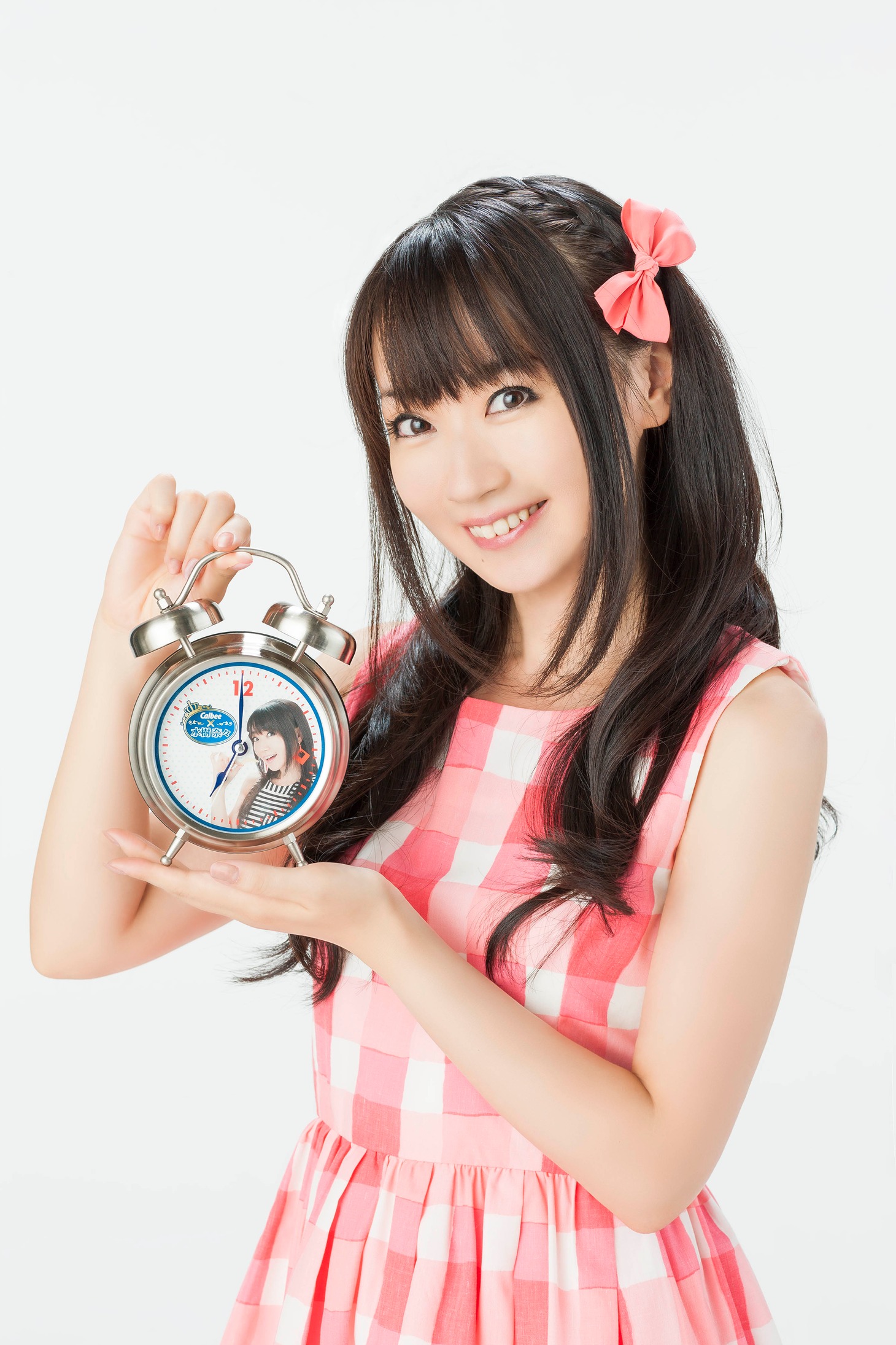 「水樹奈々 ボイス目覚まし時計」を手にする水樹奈々。